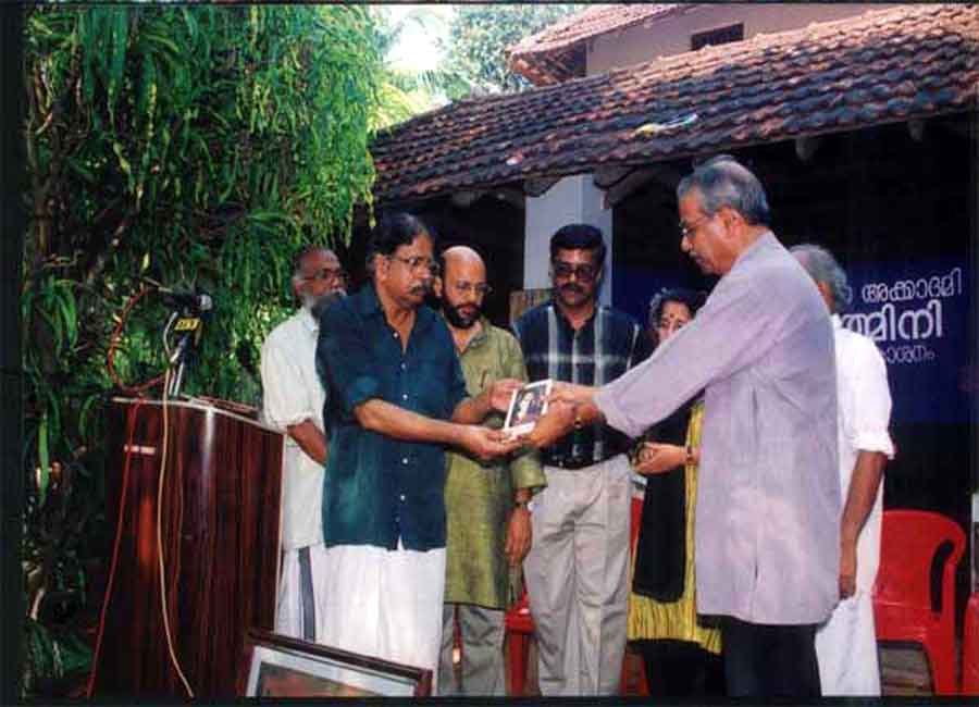 Release of the book 'T.K. Padmini, a monograph' by Mr. C. Radhakrishnan and Mr. E. Harikumar. In the background are Mr. Dayanandan, Program Convenor, Mr. R. Gopalakrishnan, Secretary of the Kerala Lalithakala Akademi, Mr. M. Sivasankar, I.A.S., Dist. Collector, Ms. Savithri Rajeevan, and Mr. T.K. Divakara Menon.